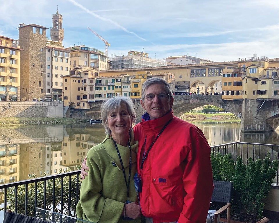A couple standing with the Florence, Italy's Ponte Vecchio bridge in the background