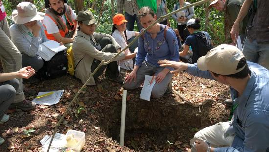 A group of students and local practitioners examining a soil pit in Panama