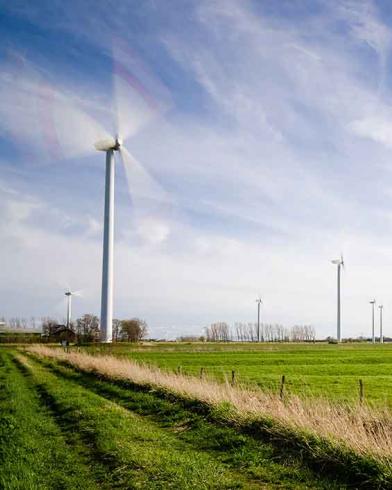 Windmills generating enery in a farm setting