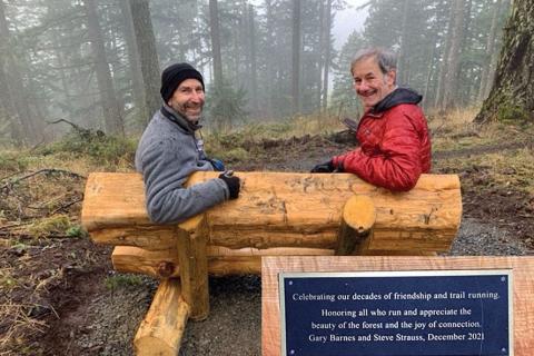 Strauss and Barnes sit on a new log bench on a favorite trail in the forest