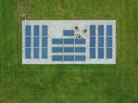 Students sitting next to an array of solar panels